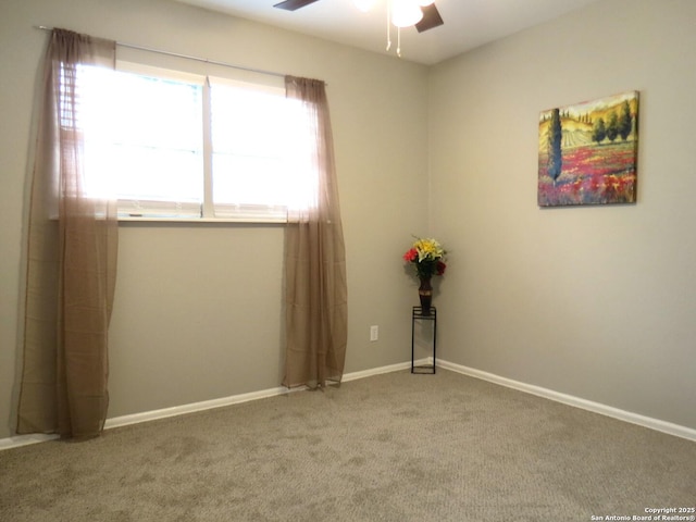 empty room featuring carpet floors, baseboards, and a ceiling fan