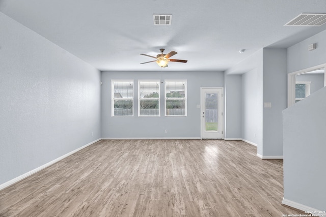 empty room with baseboards, visible vents, and light wood-style floors