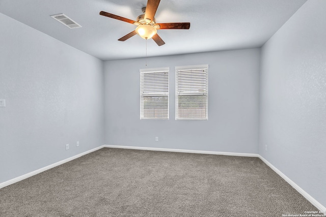 empty room featuring carpet flooring, visible vents, ceiling fan, and baseboards