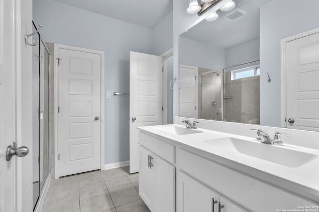 full bathroom with tile patterned flooring, visible vents, a sink, and a shower stall