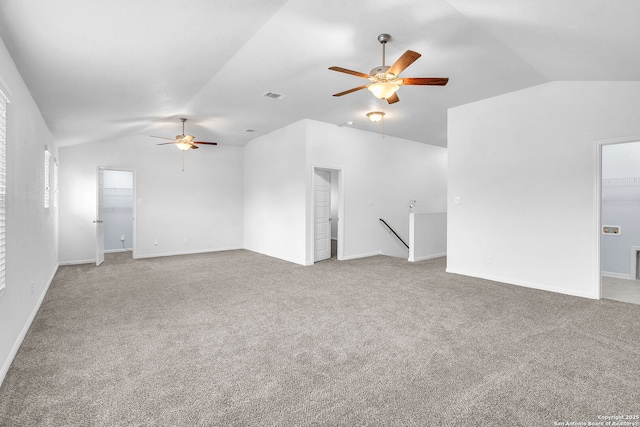 unfurnished living room with carpet floors, visible vents, vaulted ceiling, and a ceiling fan