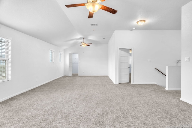 unfurnished room with light colored carpet, visible vents, a ceiling fan, vaulted ceiling, and baseboards