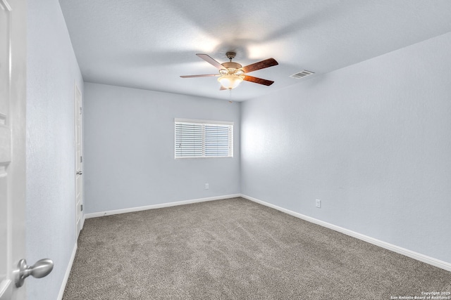 carpeted spare room with visible vents, ceiling fan, and baseboards