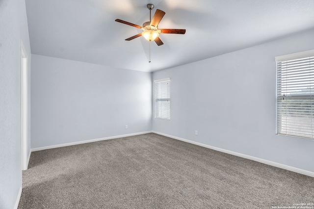 carpeted spare room featuring a ceiling fan, lofted ceiling, and baseboards