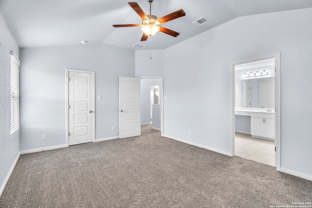 unfurnished bedroom featuring light carpet, lofted ceiling, visible vents, and baseboards