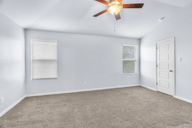 spare room featuring lofted ceiling, carpet flooring, a ceiling fan, and baseboards