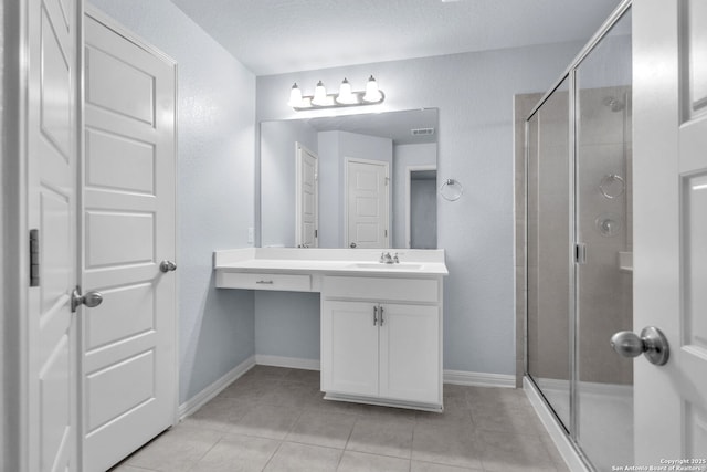 bathroom with visible vents, a shower stall, vanity, baseboards, and tile patterned floors