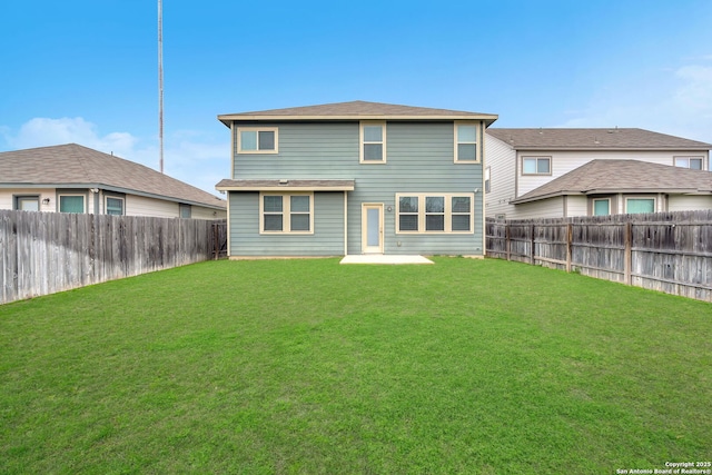 rear view of property with a lawn and a fenced backyard