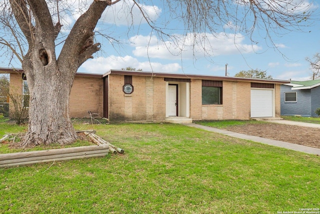 view of front of property with concrete driveway, brick siding, an attached garage, and a front yard