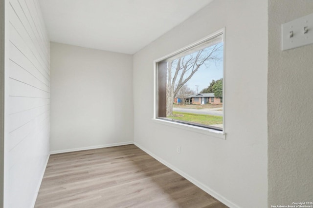 unfurnished room with light wood-style flooring and baseboards