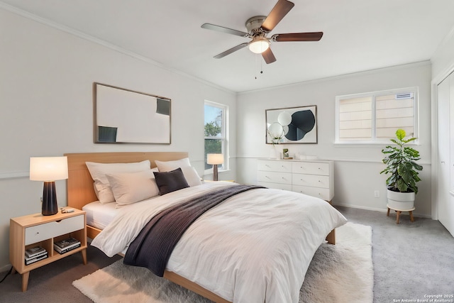 carpeted bedroom featuring baseboards, ornamental molding, and ceiling fan