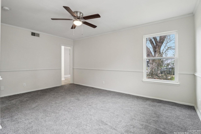 carpeted spare room with a ceiling fan, baseboards, visible vents, and crown molding