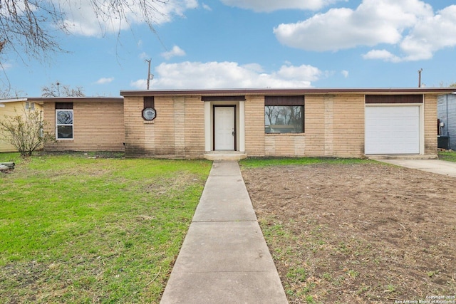 view of front of property with a garage, a front yard, concrete driveway, and brick siding