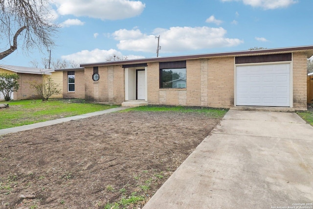 single story home featuring a front yard, brick siding, driveway, and an attached garage