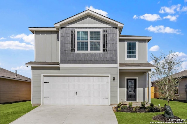 view of front of property featuring a garage, concrete driveway, board and batten siding, and a front yard