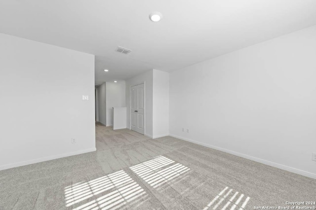 empty room featuring baseboards, recessed lighting, visible vents, and light colored carpet