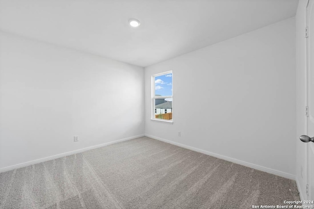 carpeted empty room with baseboards