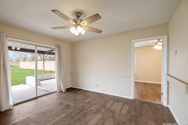 unfurnished room with ceiling fan, wood finished floors, and baseboards