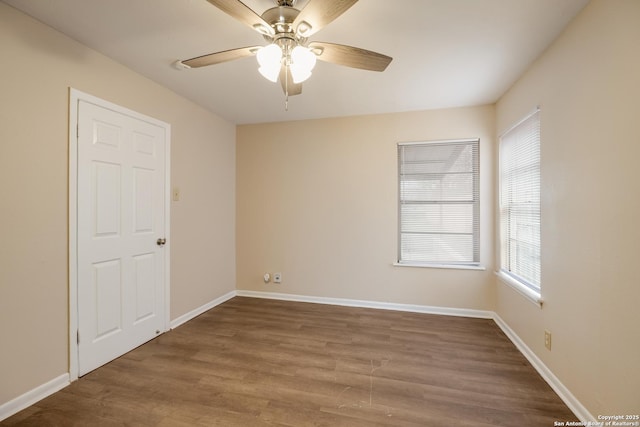 empty room featuring wood finished floors, a ceiling fan, and baseboards