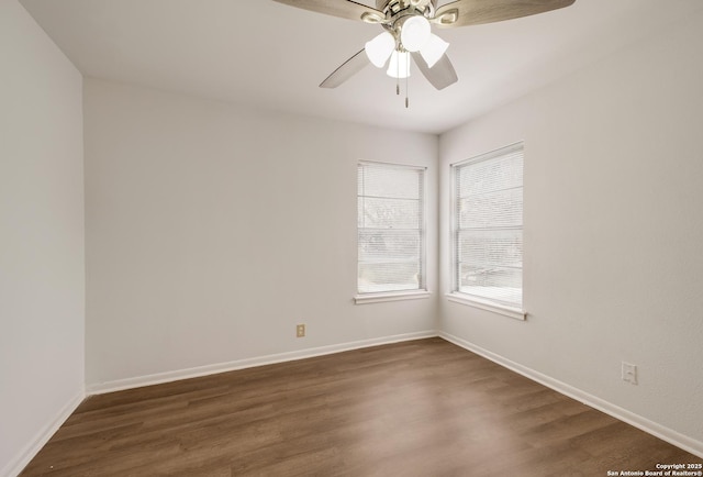 unfurnished room with a ceiling fan, baseboards, and dark wood-style flooring