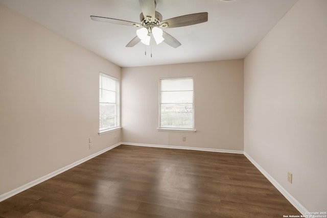 spare room featuring dark wood-style floors, ceiling fan, and baseboards