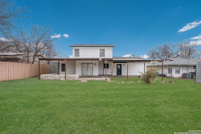 back of house featuring an attached garage, central air condition unit, fence, a yard, and a patio area