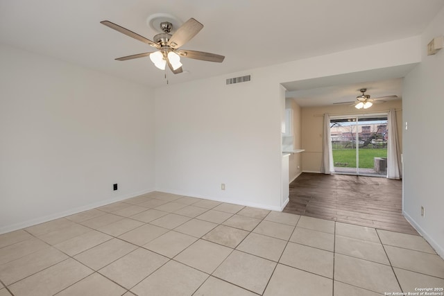 unfurnished room featuring light tile patterned floors, baseboards, visible vents, and a ceiling fan