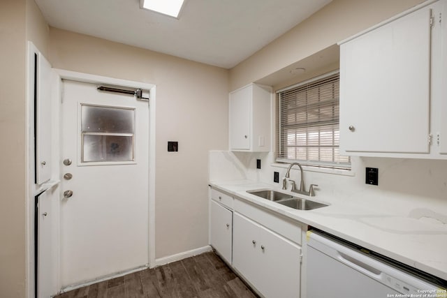 kitchen featuring light countertops, white dishwasher, a sink, and white cabinetry