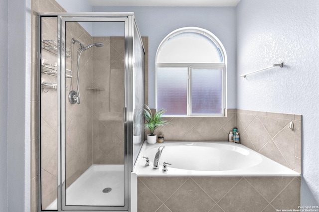 bathroom featuring a shower stall and a bath