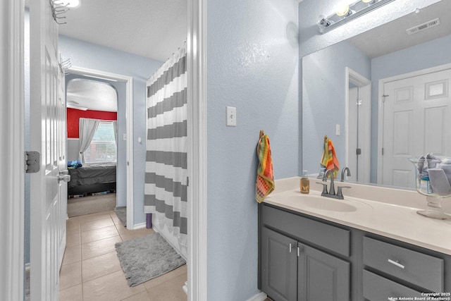 bathroom featuring tile patterned floors, vanity, visible vents, a shower with curtain, and ensuite bath