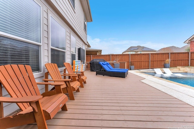 wooden deck featuring a grill, fence, and a fenced in pool