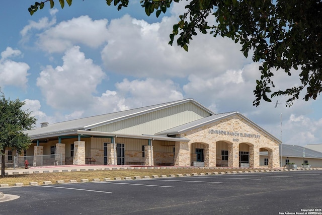 view of building exterior with uncovered parking and fence