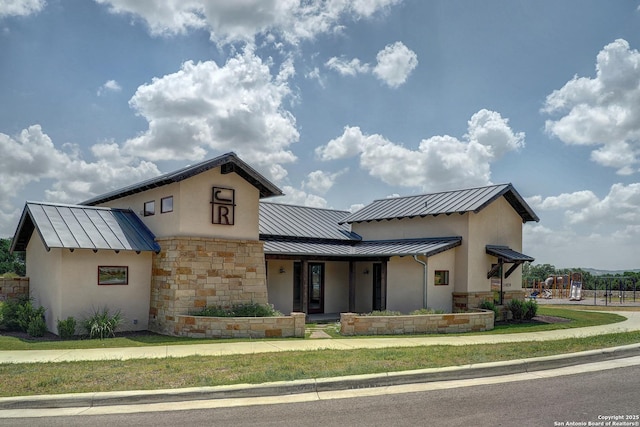 view of front of home featuring stone siding, a standing seam roof, metal roof, and stucco siding