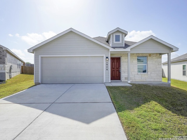 view of front of house with an attached garage, fence, stone siding, driveway, and a front lawn