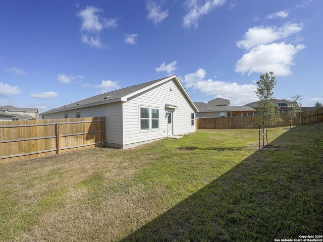 back of property featuring a lawn and a fenced backyard