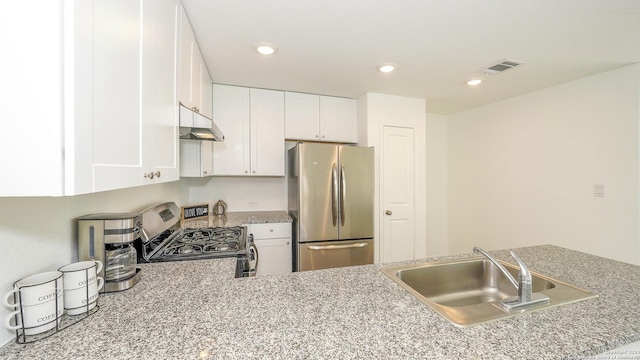 kitchen with white cabinets, a peninsula, stainless steel appliances, a sink, and recessed lighting