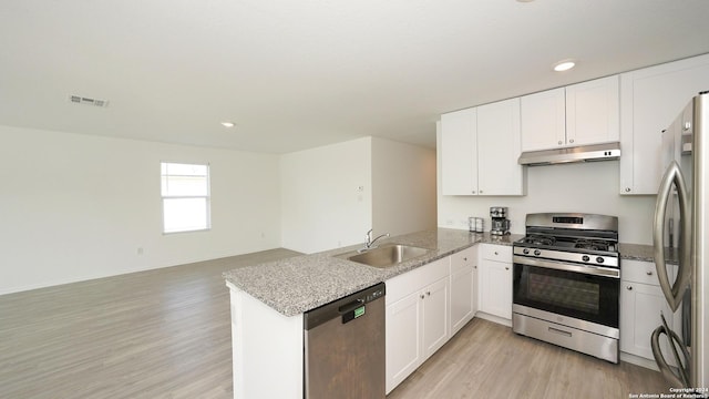 kitchen featuring visible vents, appliances with stainless steel finishes, a sink, a peninsula, and under cabinet range hood