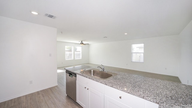 kitchen featuring a sink, white cabinetry, open floor plan, dishwasher, and light wood finished floors