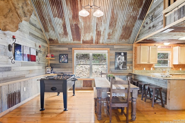 interior space with wood ceiling, vaulted ceiling, wooden walls, and light wood finished floors