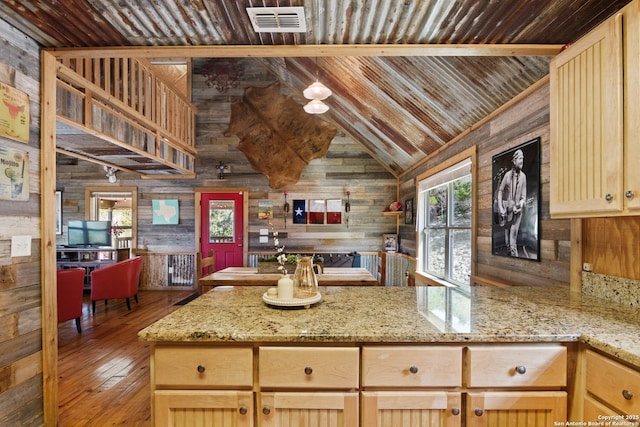 kitchen with light stone countertops, open floor plan, visible vents, and light brown cabinetry