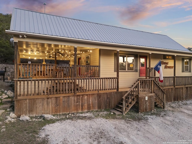 view of front of house featuring metal roof and stairs