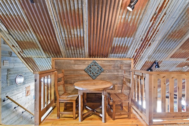 dining area featuring light wood finished floors and wooden walls