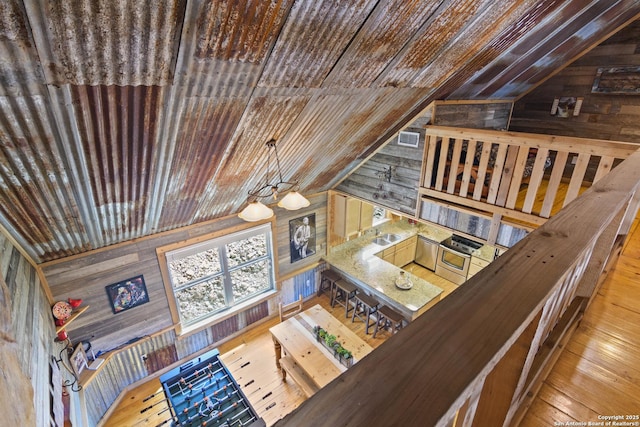 living room featuring lofted ceiling, wood walls, wooden ceiling, and visible vents