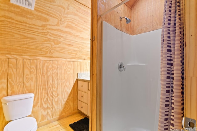 full bathroom featuring toilet, curtained shower, wood finished floors, and visible vents