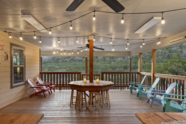 wooden terrace featuring outdoor dining area and ceiling fan