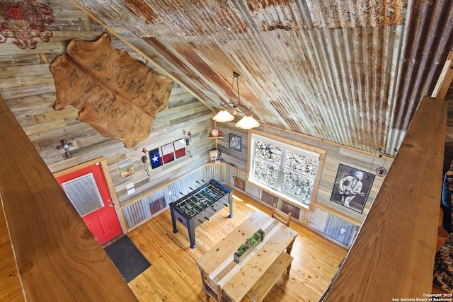 living area featuring wooden ceiling, wood walls, and wood finished floors