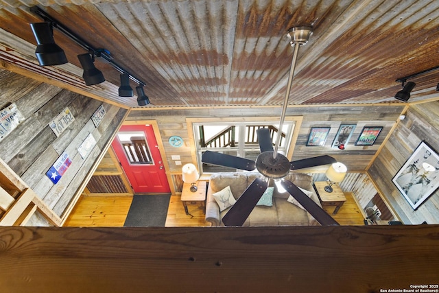 interior details with wood finished floors, wood walls, rail lighting, and wood ceiling