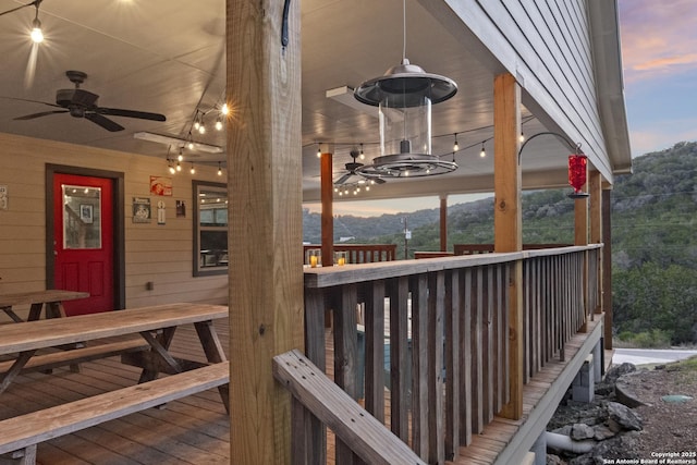 deck at dusk featuring ceiling fan