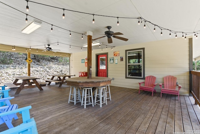 wooden terrace featuring ceiling fan, outdoor dry bar, and outdoor dining space