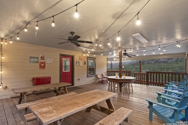 wooden terrace with ceiling fan and outdoor dining area